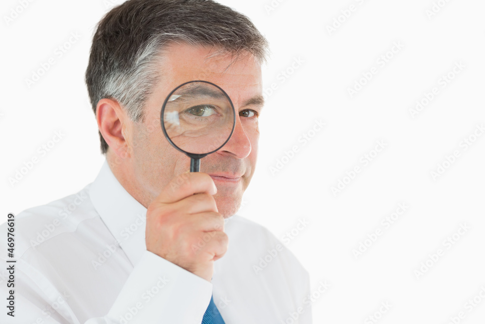 Businessman looking through magnifying glass Businessman looking through magnifying glass