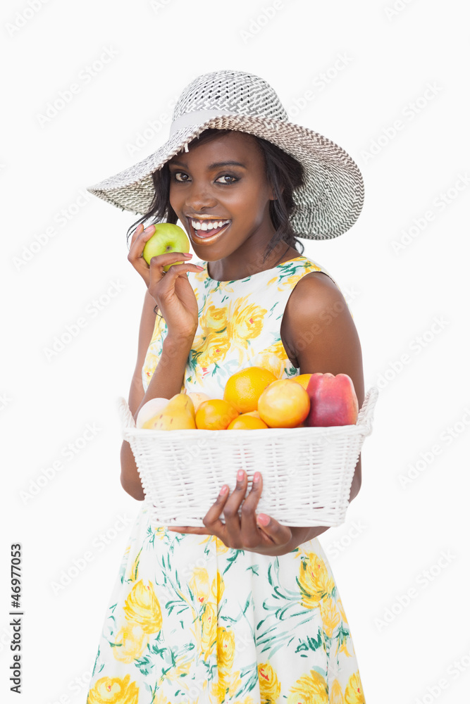 Woman holding a fruit basket and an apple