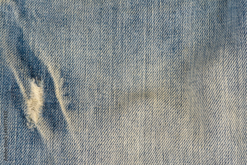 Textura de la tela de unos jeans usados y desgastados photo