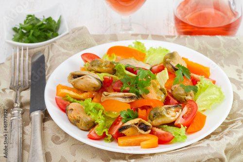 salad with mussels on the plate and glass of wine
