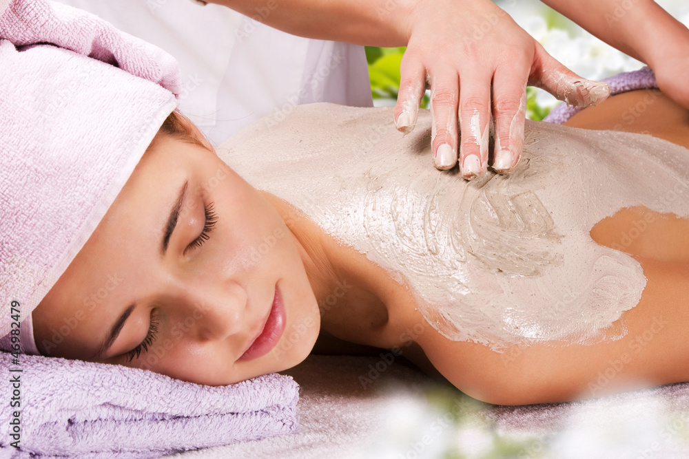 Young woman with slimming body thermal mask on her back. Spa Tre
