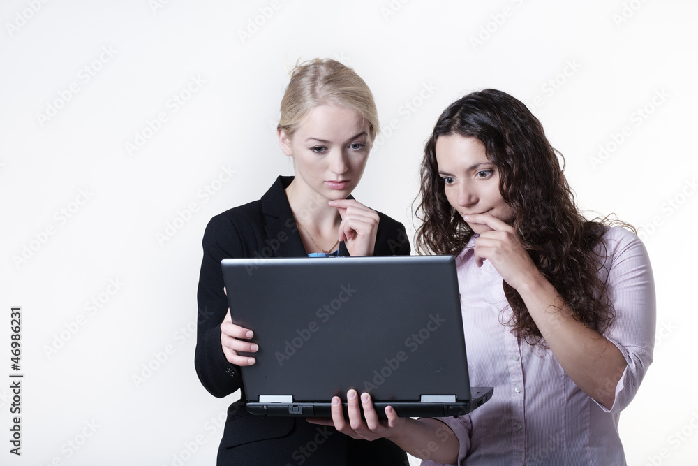 two woman  looking at computer screen