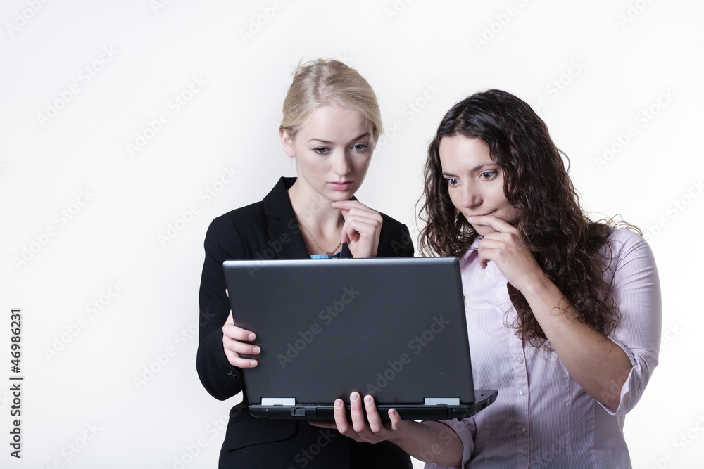 two woman looking at computer screen two woman looking at computer screen