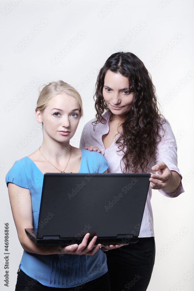 two woman looking at computer screen two woman looking at computer screen