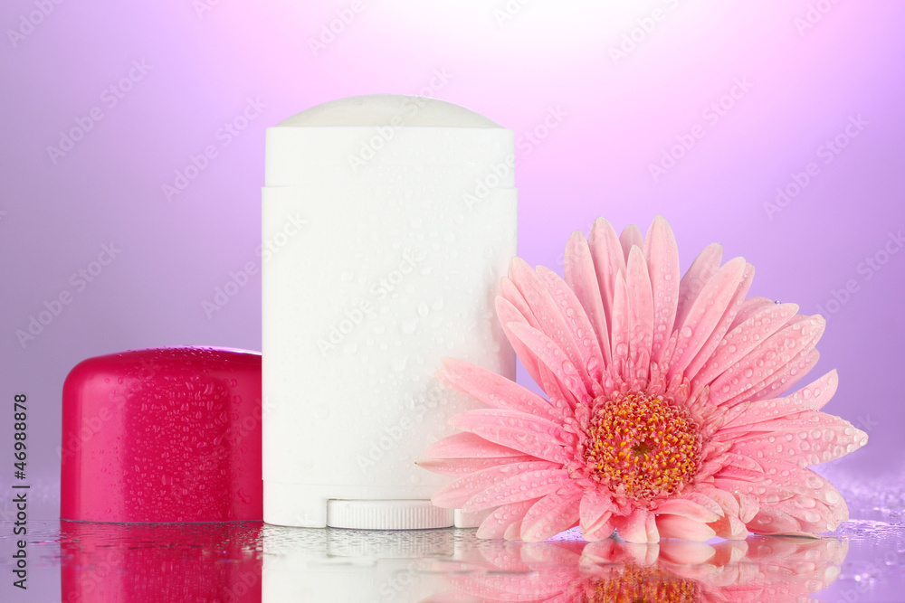 deodorant with flower on purple background deodorant with flower on purple background