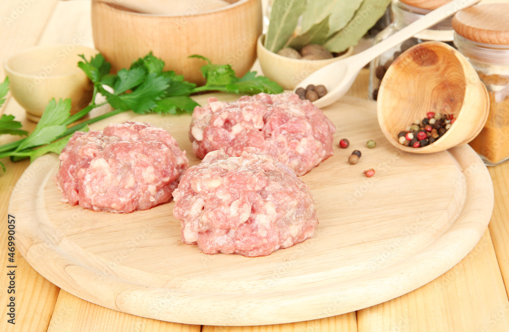 Raw meatballs with spices on wooden table Raw meatballs with spices on wooden table