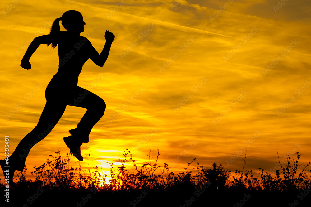 Silhouette of young sports woman running in the summer nature at sunrise Silhouette of young sports woman running in the summer nature at sunrise