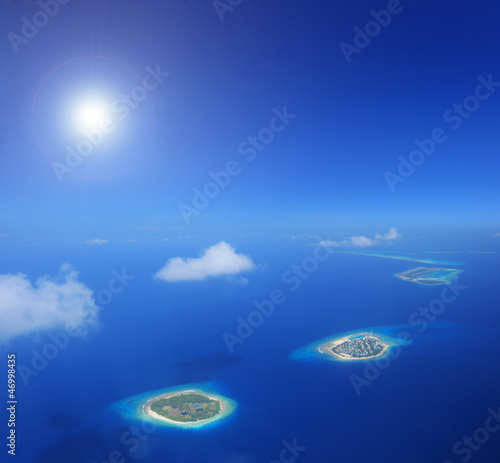 Sun and clouds over islands in Laccadives sea, Maldives