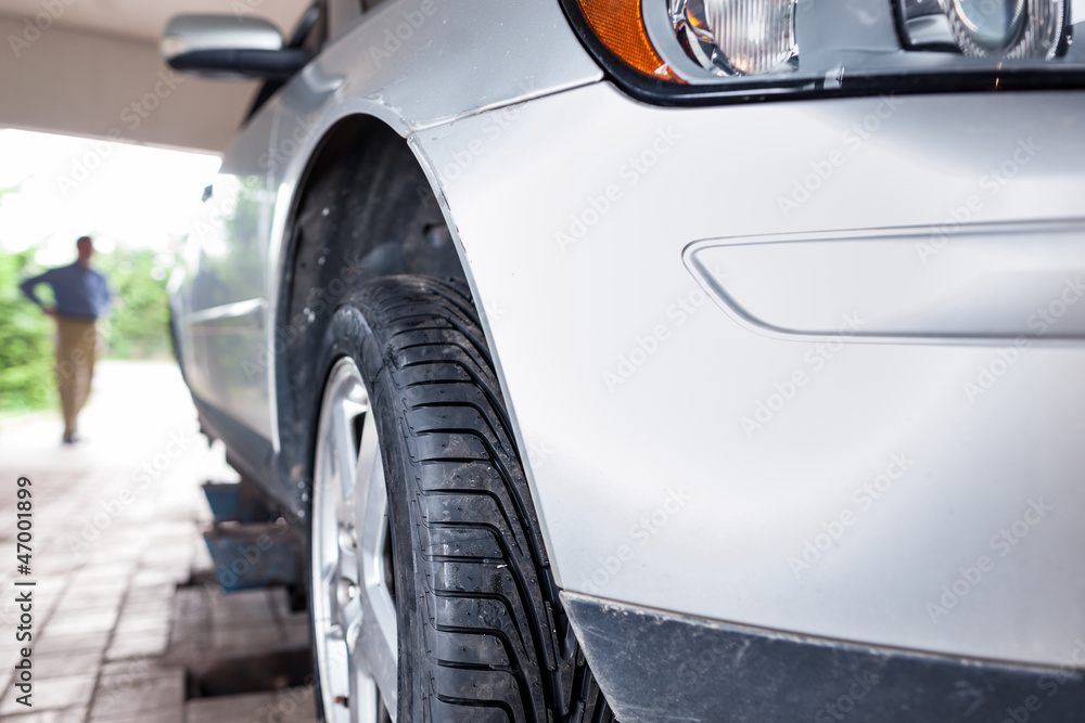 Client waiting while his car is being inspected in a garage