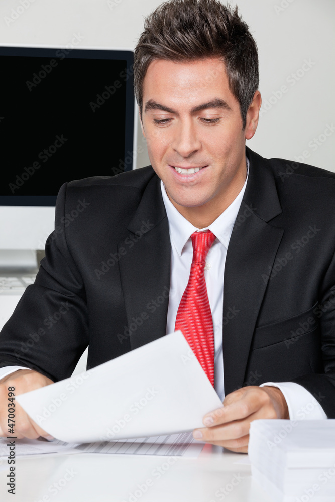 Businessman Reading Document In Office Businessman Reading Document In Office