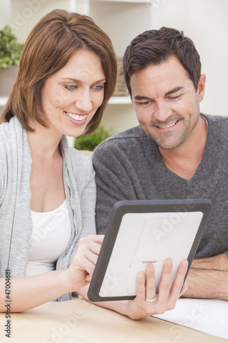 Happy Man & Woman Couple Using Tablet Computer at Home © Darren Baker