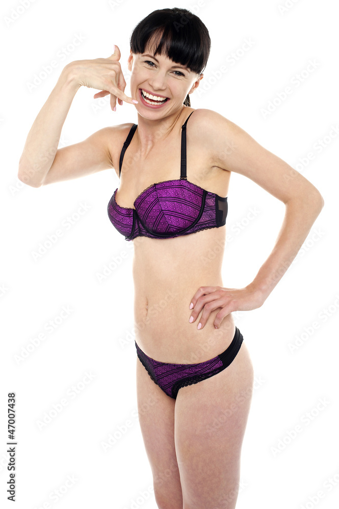 Attractive brunette in bikini gesturing a mock call Attractive brunette in bikini gesturing a mock call