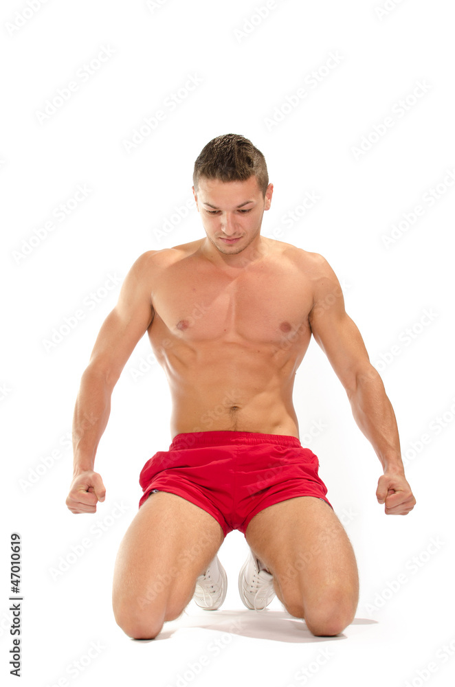Portrait of young muscular man on his knees stretching Portrait of young muscular man on his knees stretching