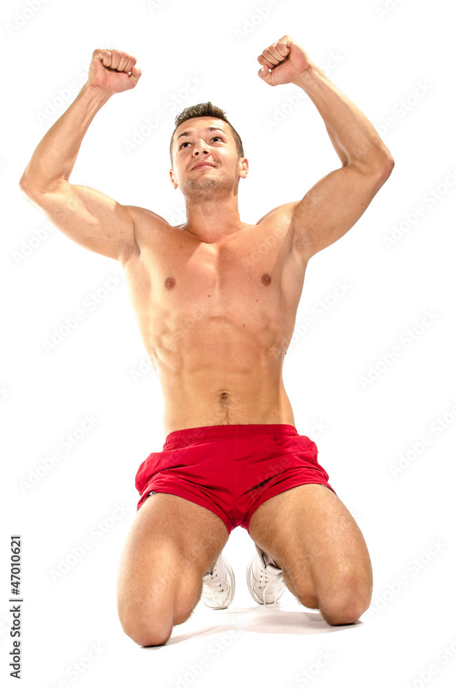 Portrait of young muscular man showing victory