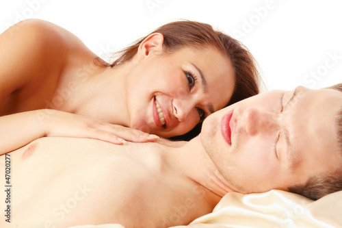 A couple is lying in bed on white background