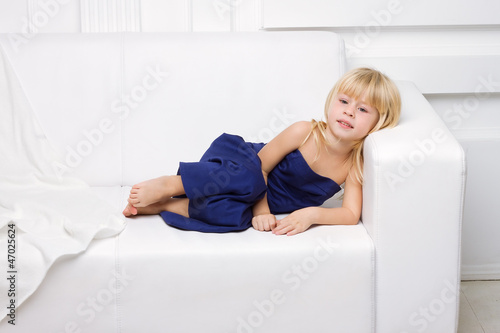 girl is in blue dress on a white sofa