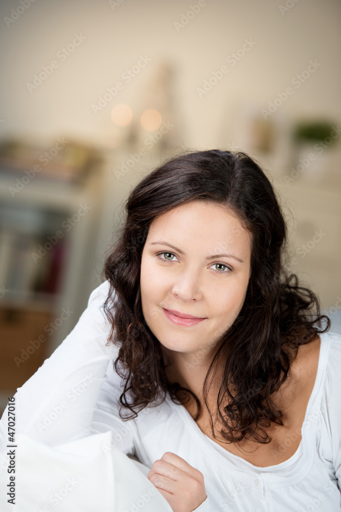 frau sitzt abends entspannt auf dem sofa frau sitzt abends entspannt auf dem sofa