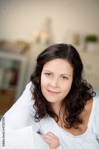 frau sitzt abends entspannt auf dem sofa