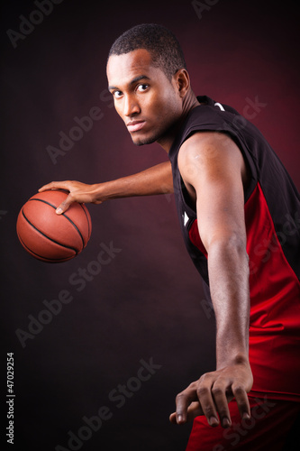 Portrait of a young male basketball player against black backgr © cristovao31