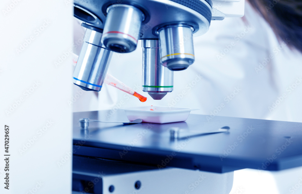 Closeup of female scientist working on a microscope Closeup of female scientist working on a microscope