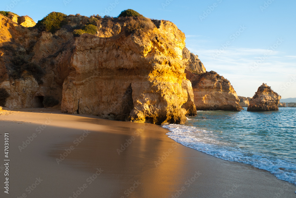 luz dourada nas rochas da praia