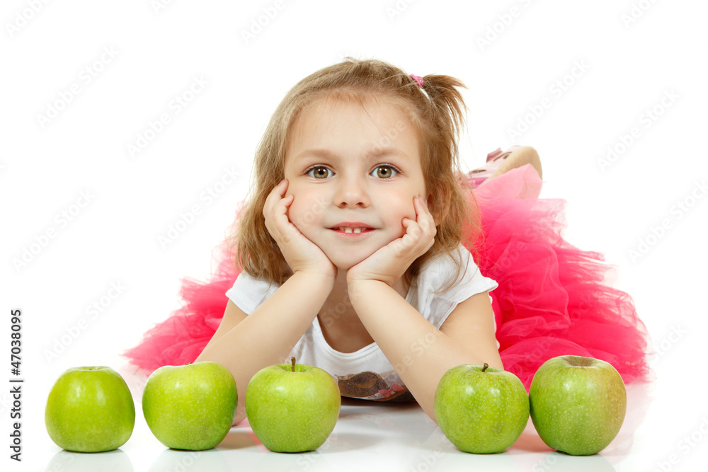 Fototapeta premium Cute little girl lying and playng with apples.