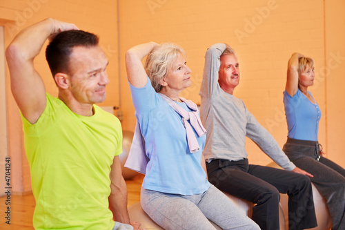 Senioren dehnen sich im Fitnesscenter