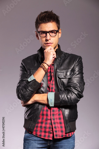 pensive young man with leather jacket and glasses