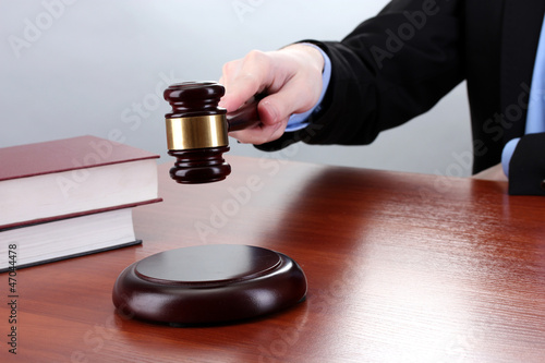 wooden gavel in hand and books