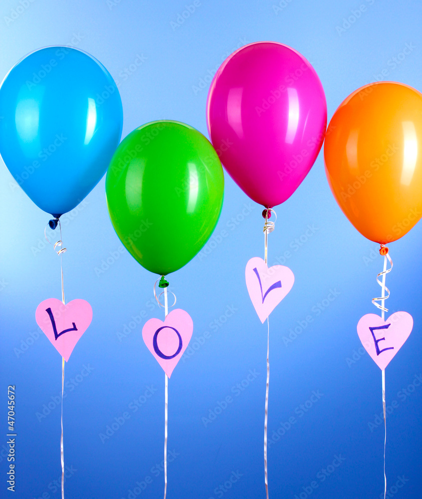 Colorful balloons keeps word love on blue background