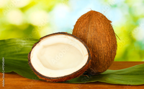 coconut with green leaf on green background close-up