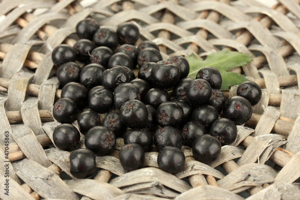 chokeberry with green leaf on wicker mat close-up