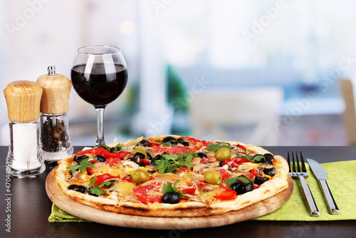 Delicious pizza with glass of red wine and spices