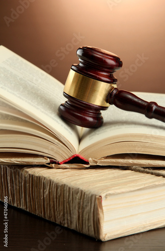 wooden gavel on books, on brown background