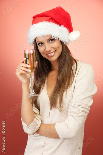 beautiful young woman with glass of champagne  on red