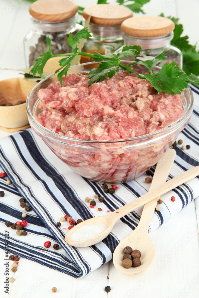 Bowl of raw ground meat with spices on wooden table Bowl of raw ground meat with spices on wooden table