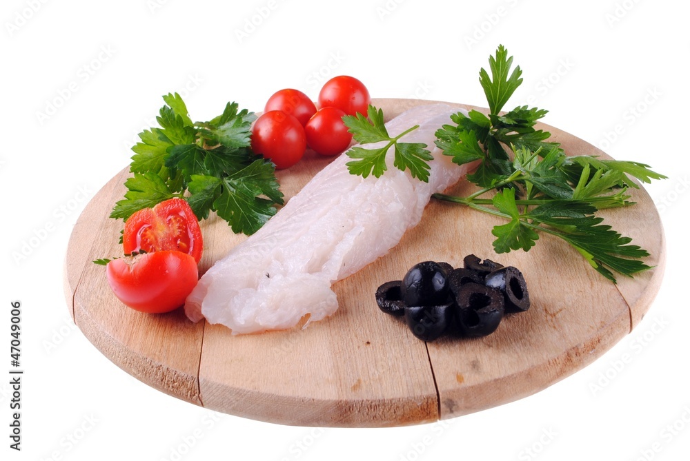 cod steak with tomatoes olives and parsley on a wooden board cod steak with tomatoes olives and parsley on a wooden board