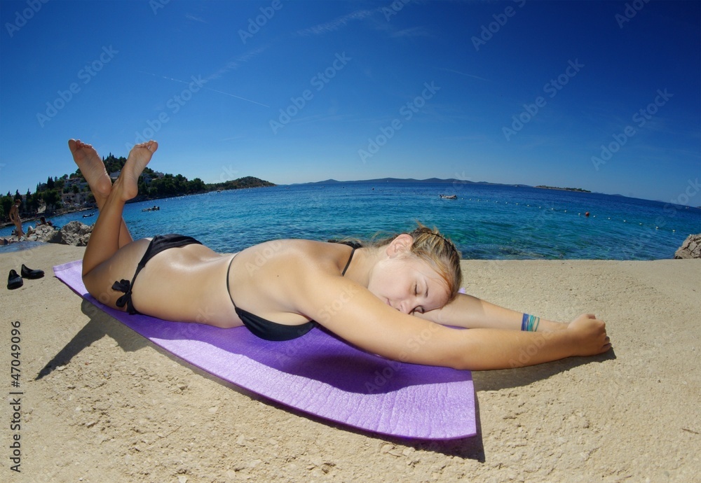 Young woman, sunbathing on a beach Young woman, sunbathing on a beach