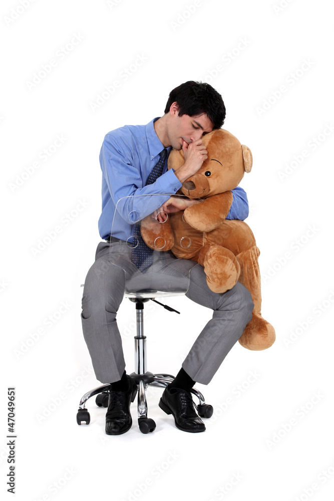 An adult businessman hugging a big teddy bear. An adult businessman hugging a big teddy bear.