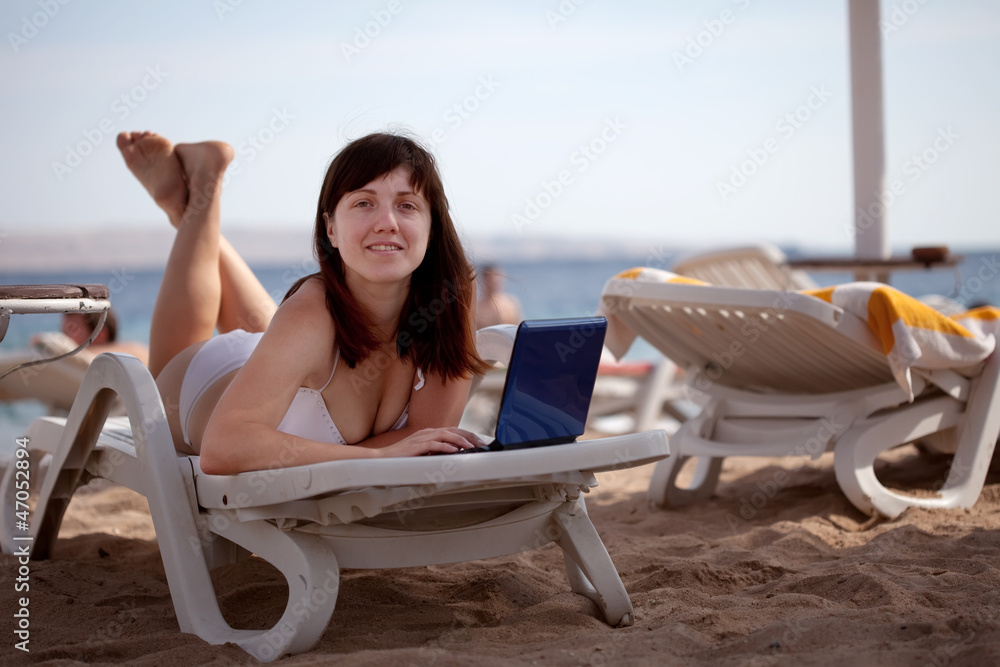  woman  with laptop at resort beach