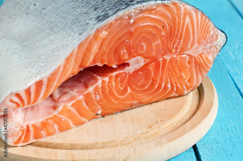 Raw salmon on board on blue wooden background