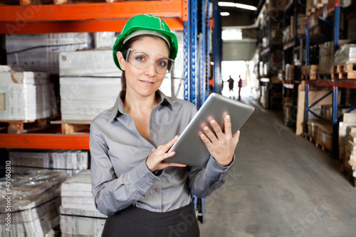 Female Supervisor Using Digital Tablet At Warehouse