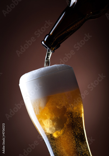 beer glass and bottle on a brown