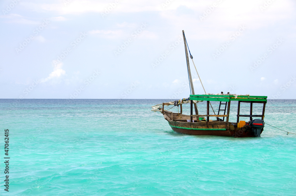 Wooden boat floating on the turquoise sea Wooden boat floating on the turquoise sea