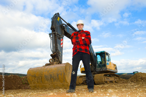 building worker in front of excavator