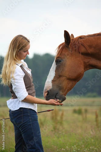 Woman giving horse a treat