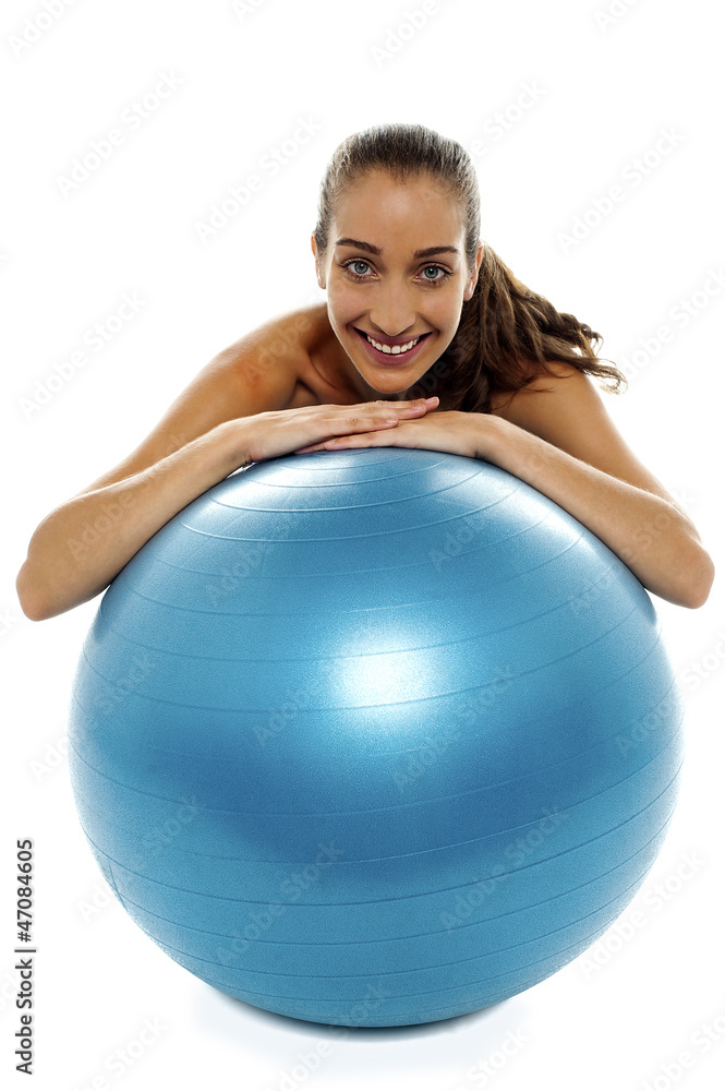 Woman leaning over big blue swiss ball Woman leaning over big blue swiss ball