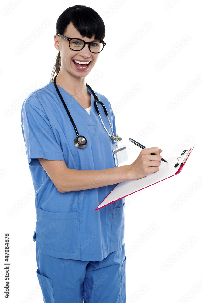 Medical nurse jotting down notes on writing pad Medical nurse jotting down notes on writing pad