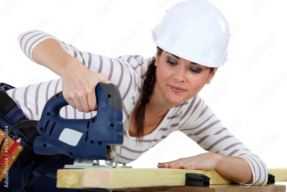 Female carpenter using a jigsaw. Female carpenter using a jigsaw.