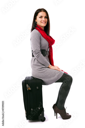 Young woman sitting on luggage